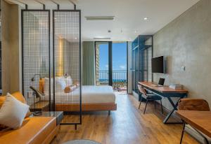 岘港Taiyo Hotel & Apartment的配有一张床和一张书桌的酒店客房