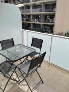 贝尼卡洛Benicarlo Puerto的阳台上的玻璃桌和两把椅子