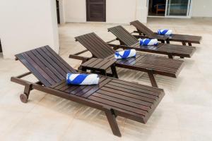 南圣胡安Seaside Serenity at Casa Cala Azul home的四个带蓝色枕头的木椅,位于房间里