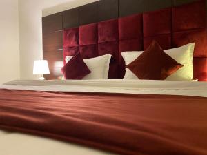 Abḩur al Janūbīyahايزي للوحدات المخدومة的一间卧室配有一张大床和红色床头板