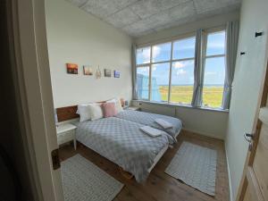 尼堡Skærven Beachfront Apartments and Cottage的一间卧室设有一张床和一个大窗户