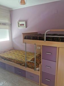 贝尼卡洛Benicarlo Puerto的配有两张双层床的紫色橱柜