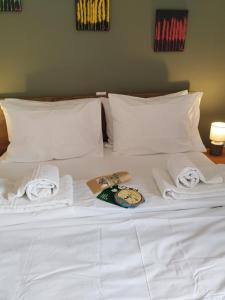 希俄斯ISLAND TIME的一张带毛巾的白色床和一本书
