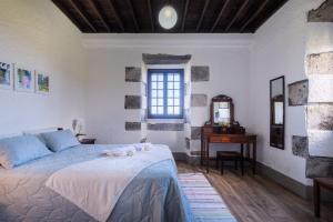 Feteira GrandeOcean View - Nordeste的一间卧室配有一张床、一张桌子和一个窗户。