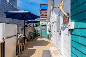海洋海滩The Blue Parrot Guest House的一条带蓝色建筑和遮阳伞的小巷