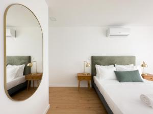 波尔图Vibrant Porto Apartments-Campo 24 Agosto的一间带镜子和床的卧室