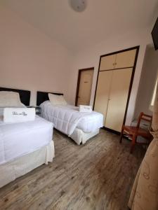科洛尼亚-德尔萨克拉门托Hotel Perla del Plata的酒店客房,设有两张床和镜子