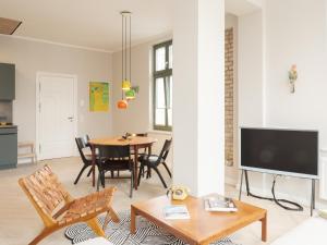 塞巴特阿尔贝克OSTKÜSTE - Villa Steigel Design Apartments的客厅配有桌子和电视