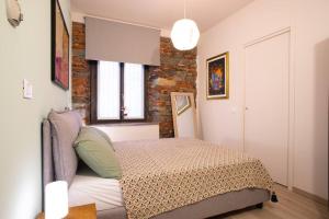 阿罗纳Baby Art Apartment的一间卧室设有一张床和砖墙