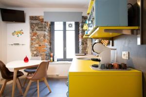 阿罗纳Baby Art Apartment的厨房设有黄色的柜台和桌子
