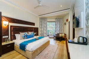 卡绍利Hotel Montrose Kasauli !! Balcony Rooms !! Terrace !! Restaurant !! Spa的一间卧室配有一张带蓝色枕头的大床