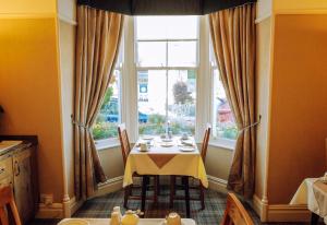 凯西克阿万达宾馆的一间带桌子和窗户的用餐室