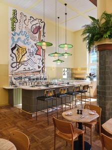 阿姆斯特丹The Hoxton, Lloyd Amsterdam的一间带桌椅和大型壁画的餐厅