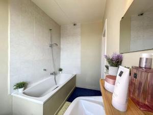 米德尔克尔克Holiday Home Sungarden的带浴缸和盥洗盆的浴室