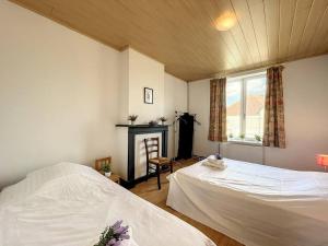 米德尔克尔克Holiday Home Sungarden的一间卧室设有两张床、一个壁炉和一个窗口。