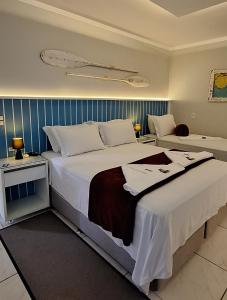 纳韦甘蒂斯NAVEGA PRAIA HOTEL的酒店客房带一张大床,带白色床单