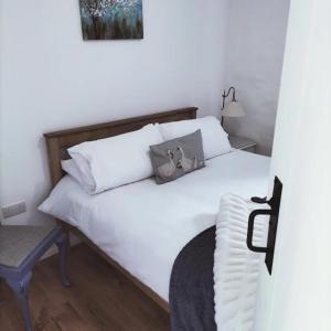 利马瓦迪Ballymultimber Cottages的卧室配有白色的床和椅子