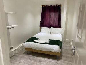 伦敦W3 Guest House的一间小卧室,配有一张带紫色窗户的床