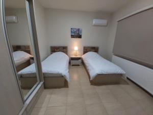 马达巴CMK Housing的小房间设有两张床和镜子