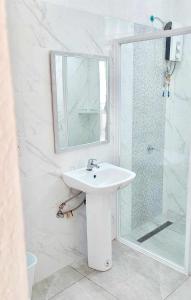 PoocTiki Bantayan Cebu Tourist Inn Inc的白色的浴室设有水槽和镜子