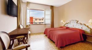 卡尼洛瑞维拉Residenza dei Fiori的一间卧室设有两张床、一张桌子和一个窗口。