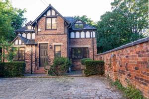 曼彻斯特Detached house with gated parking in Whalley Range的砖墙的旧砖房子