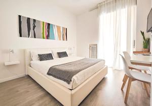 维罗纳Corte Melone room rental的白色卧室配有一张大床和一张书桌