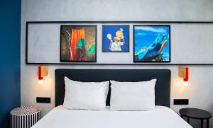 阿比让Ibis Styles Abidjan Plateau的卧室配有一张四幅画的墙壁床。