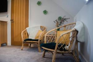 阿宾汉姆Sam's Place Apartment in Uppingham, Rutland的两把藤椅坐在一个有门的房间