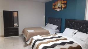 特鲁希略HOSPEDAJE BLESS的一间卧室设有两张床和蓝色的墙壁