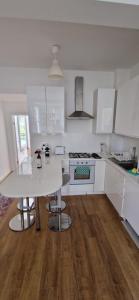 伦敦Primrose Hill - Charming, Cosy, 2 Double Bedrooms Apartment的厨房配有白色橱柜和白色桌子