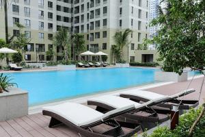 胡志明市Cozy 2 Bedroom Condo in Masteri Thao Dien, Fully Furnished With Full Amenities的一个带躺椅的游泳池和一间酒店