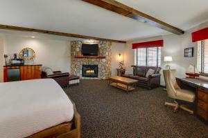 皮奥里亚Stoney Creek Hotel Peoria的一间卧室设有一张床,客厅设有壁炉。