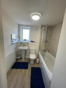 米尔顿凯恩斯Spacious Apartment in Brooklands的浴室配有卫生间、盥洗盆和淋浴。