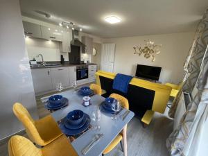 米尔顿凯恩斯Spacious Apartment in Brooklands的厨房以及带桌椅的用餐室。