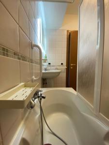 基奥贾Cometa Beach House的白色的浴室设有浴缸和水槽。