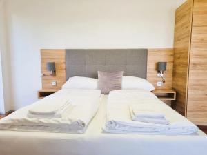 林茨Mountains and Lakes - Villa Gaumberg的一间卧室配有两张带白色床单和两盏灯的床。