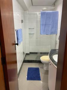 维多利亚APARTAMENTO SOL E MAR VITÓRIA的浴室设有卫生间、水槽和蓝色毛巾。