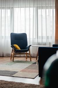 阿拉木图Cozy Home Exclusive Time的客厅里一张带黄色枕头的蓝色椅子