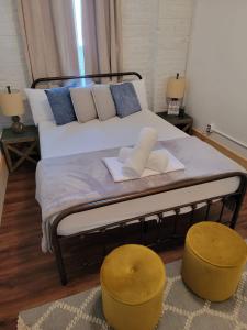 克拉克斯代尔HOSTEL Auberge Clarksdale的一间卧室配有一张带两张黄色凳子的床