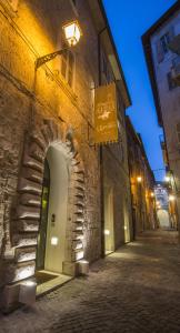 阿斯科利皮切诺阿尔伯格桑特艾米蒂欧酒店的街上的石头建筑,晚上有拱门