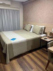 特雷西纳Gran Hotel Arrey的一间卧室配有一张大床、一张桌子和一台电脑