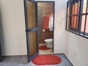 洛美Fafape的一间带卫生间和红色地毯的浴室