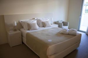 蓬德利马荫利马酒店及水疗中心的卧室配有一张带白色床单和枕头的大床。