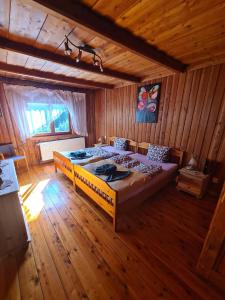 希维拉杜夫-兹德鲁伊Sępia Chata Dom Do Wynajęcia的木制客房内的一间卧室配有一张大床