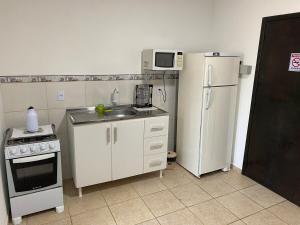 约恩维利EDIFÍCIO KARINE - STUDIO n⁰ 04的一间带水槽和冰箱的小厨房
