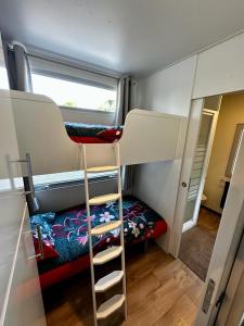 勒格劳德阿格德Mobil home 3 chambres avec jacuzzi的小房间设有两张双层床和窗户