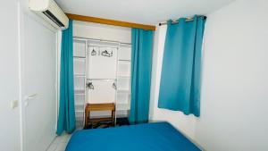 圣弗朗索瓦Le Colibri des Alizés的配有床和蓝色窗帘的房间