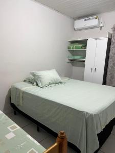 帕罗卡Residencial Coração do Mar的小卧室配有一张带绿毯的床
