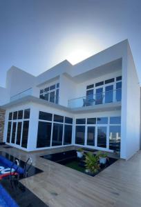 阿夏尔奇亚bh villa的一座大型白色房子,前面设有一个游泳池